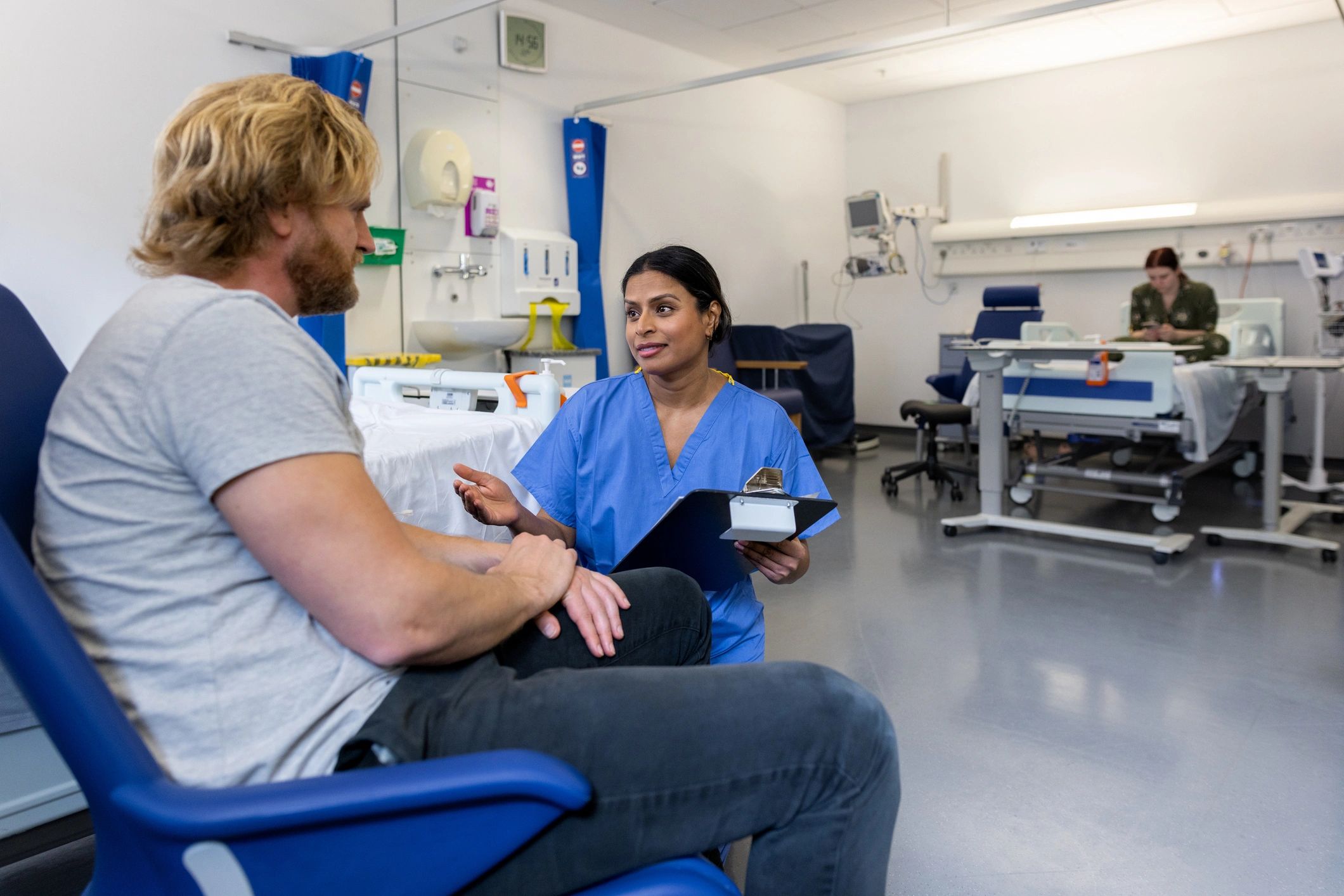 Clinician explaining a care program to a seated patient
